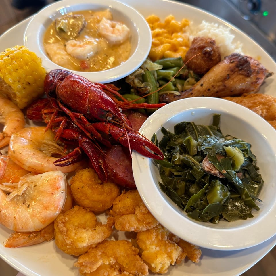 A large platter of Georgia Comfort Kitchen's seafood boil with crawfish, shrimp, corn, and sides.
